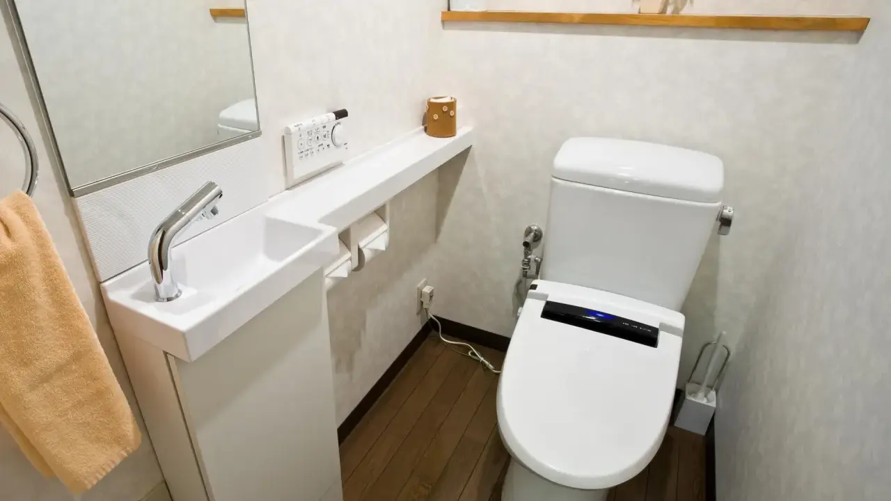 Kompaktowe, bardzo małe WC aranżacje z nowoczesną toaletą, małą umywalką i lustrem.
