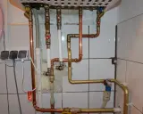 Instalacja pieca gazowego z zamkniętą komorą spalania wymaga precyzyjnego połączenia rur miedzianych i złotych.