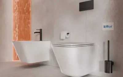 Nowoczesna zabudowa w łazience: wisząca miska WC i bidet z czarną armaturą, obok uchwyt na papier i szczotka.