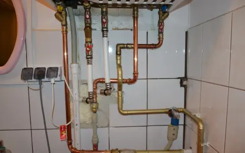 Instalacja pieca gazowego z zamkniętą komorą spalania wymaga precyzyjnego połączenia rur miedzianych i złotych.