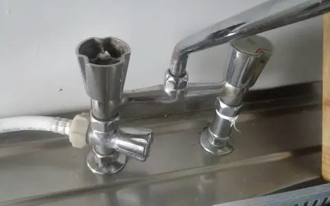 Zepsuty kran, jak odkrecic kran? Widoczne są dwa pokrętła, jedno z osadem.