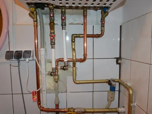 Instalacja pieca gazowego z zamkniętą komorą spalania wymaga precyzyjnego połączenia rur miedzianych i złotych.