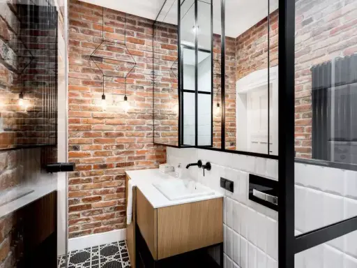 Łazienka w stylu industrialnym, loft z ceglanymi ścianami, drewnianą szafką i czarnymi akcentami.