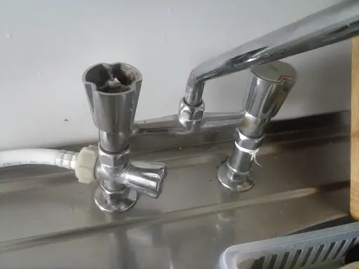 Zepsuty kran, jak odkrecic kran? Widoczne są dwa pokrętła, jedno z osadem.