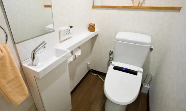 Kompaktowe, bardzo małe WC aranżacje z nowoczesną toaletą, małą umywalką i lustrem.