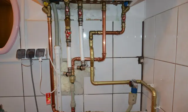 Instalacja pieca gazowego z zamkniętą komorą spalania wymaga precyzyjnego połączenia rur miedzianych i złotych.