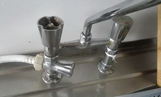 Zepsuty kran, jak odkrecic kran? Widoczne są dwa pokrętła, jedno z osadem.
