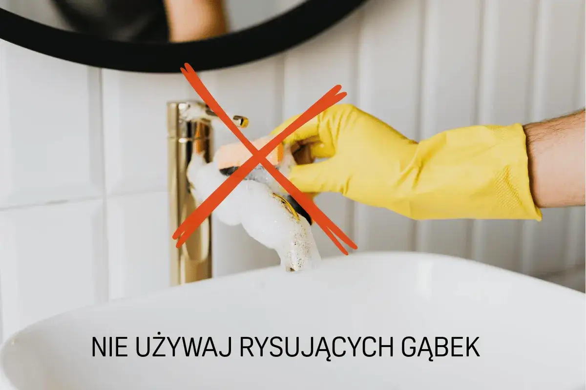 Ręka w ż&oacute;łtej rękawiczce pr&oacute;buje wyczyścić baterię łazienkową, ale czerwony krzyżyk ostrzega przed użyciem szorstkich gąbek, kt&oacute;re mogą powodować ciemne plamy na baterii.
