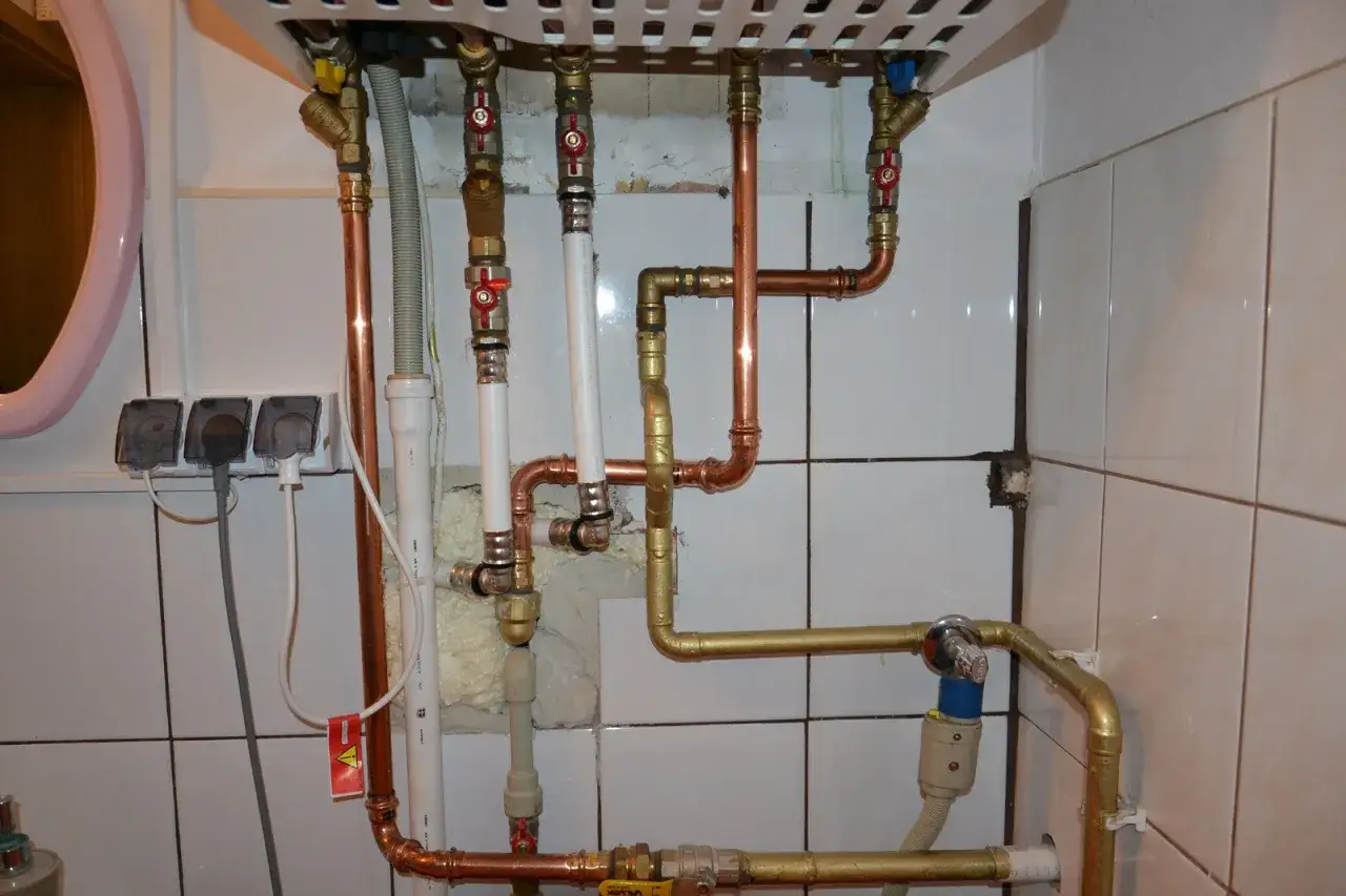 Instalacja pieca gazowego z zamkniętą komorą spalania wymaga precyzyjnego połączenia rur miedzianych i złotych.